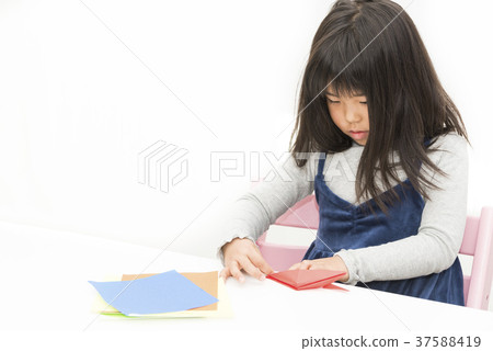 Girl making a crane with origami 37588419
