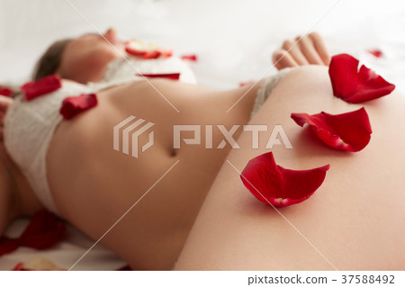 Rose petals on hip of sexy lingerie model Rose petals on hip of sexy lingerie model 37588492