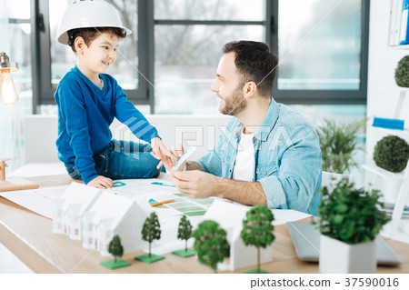 Smiling architect asking his son to choose a color 37590016
