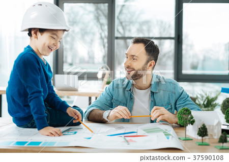 Little boy being interested in results of fathers 37590108