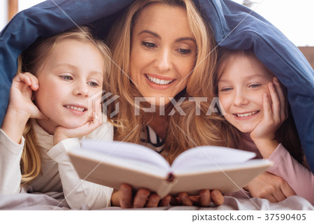Cheerful mom reading a book for her daughters 37590405