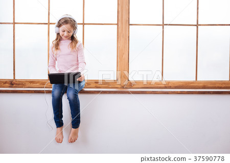 Joyful girl wearing headphones and listening to 37590778