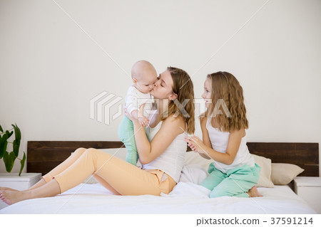 three girls play sisters in the morning on the bed 37591214