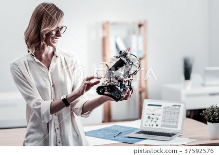 Joyful engineer checking up her robot Joyful engineer checking up her robot 37592576