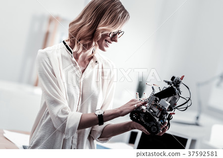 Cheerful girl examining her invention Cheerful girl examining her invention 37592581