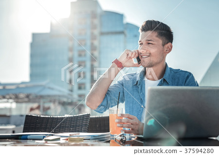 Handsome gentleman enjoying phone conversation on 37594280