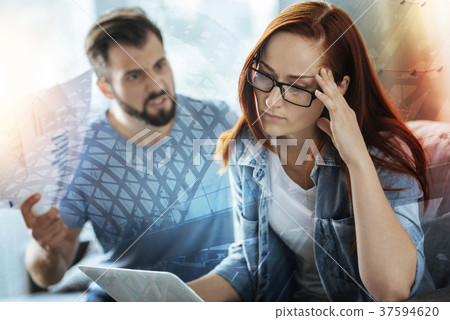 Young woman touching her head while listening to 37594620