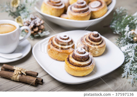 Fresh homemade buns with cinnamon, a cup of coffee 37597136