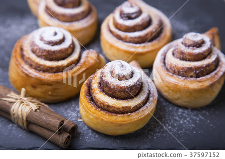 Fresh homemade buns with cinnamon, cinnamon sticks 37597152