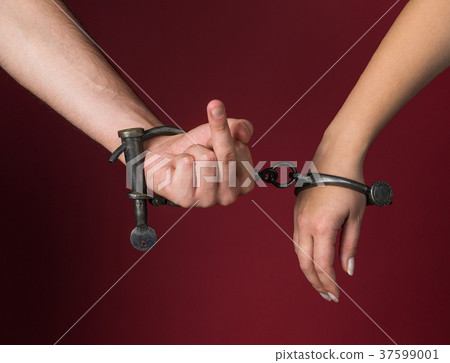 male and female hands are handcuffed. 37599001
