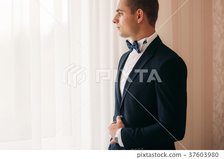 The groom is dressed at home in a suit. Cute groom The groom is dressed at home in a suit. Cute groom 37603980