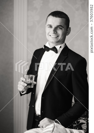 The groom is dressed at home in a suit. Cute groom The groom is dressed at home in a suit. Cute groom 37603982