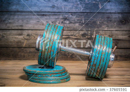 Vintage dumbbell on the wooden floor.  37605591