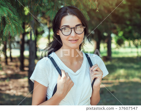 Young woman traveler with backpack standing alone Young woman traveler with backpack standing alone 37607547