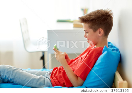 happy smiling boy with smartphone at home happy smiling boy with smartphone at home 37613595