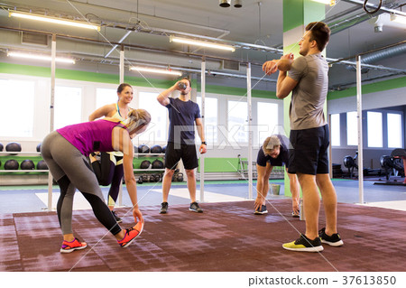group of happy friends stretching in gym 37613850