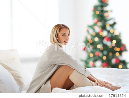 happy young woman sitting in bed at christmas happy young woman sitting in bed at christmas 37613854