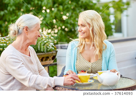 daughter with senior mother drinking tea at cafe 37614093