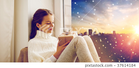 girl with christmas gift on window sill in winter girl with christmas gift on window sill in winter 37614184