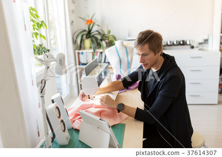 fashion designer with tablet pc sewing at studio fashion designer with tablet pc sewing at studio 37614307