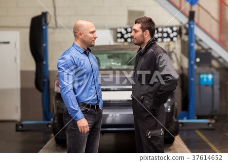 auto mechanic talking to customer at car shop auto mechanic talking to customer at car shop 37614652