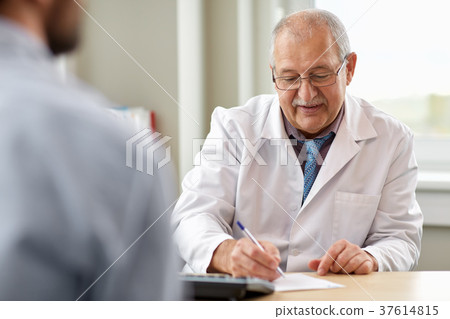doctor writing prescription for patient at clinic doctor writing prescription for patient at clinic 37614815