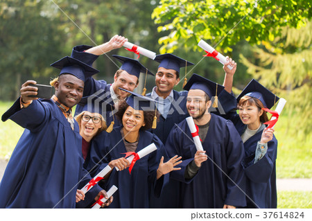 students or graduates with diplomas taking selfie students or graduates with diplomas taking selfie 37614824