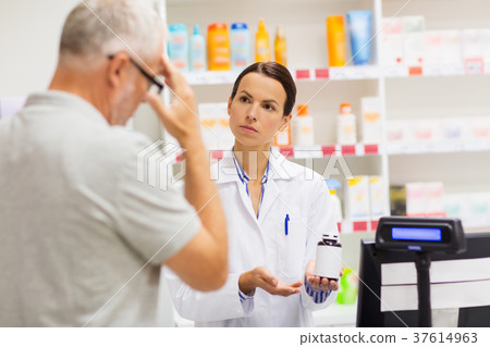 apothecary showing drug to senior man at pharmacy 37614963