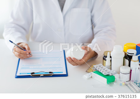 doctor with medicines and clipboard at hospital 37615135