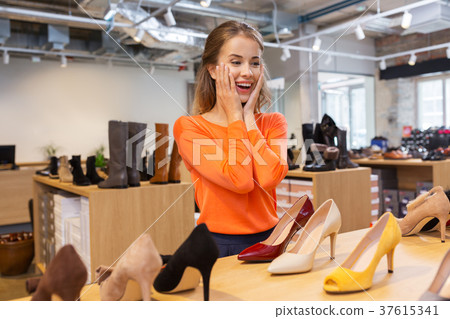 excited young woman choosing shoes at store excited young woman choosing shoes at store 37615341