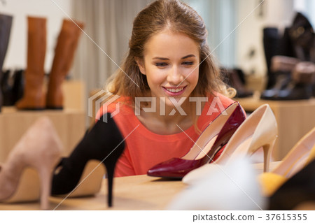 happy young woman choosing shoes at store happy young woman choosing shoes at store 37615355