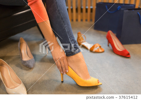 young woman trying high-heeled shoes at store young woman trying high-heeled shoes at store 37615412