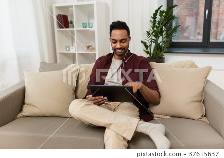 man in earphones with tablet pc listening to music man in earphones with tablet pc listening to music 37615637