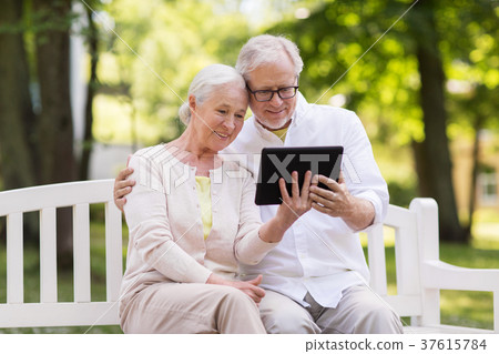 happy senior couple with tablet pc at summer park 37615784
