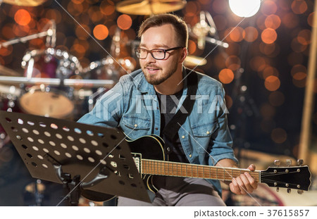 musician playing guitar at studio over lights 37615857