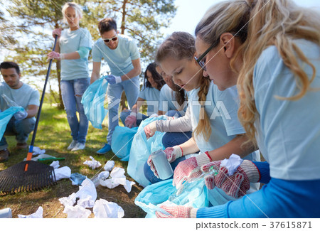 volunteers with garbage bags cleaning park area 37615871