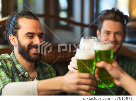 male friends drinking green beer at bar or pub 37615971