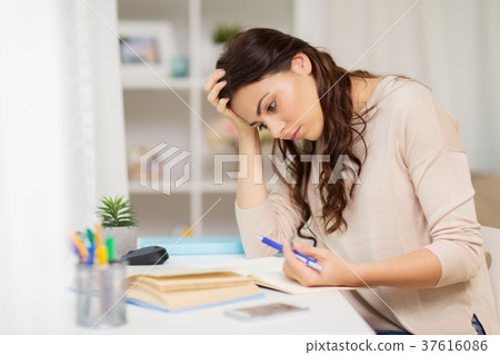 tired female student with book learning at home 37616086