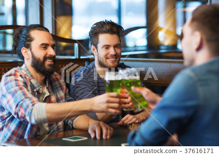 male friends drinking green beer at bar or pub male friends drinking green beer at bar or pub 37616171