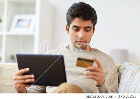 man with tablet pc and credit card at home man with tablet pc and credit card at home 37616255
