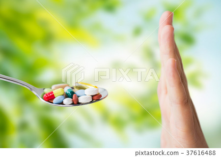 hand of woman refusing from pills on spoon 37616488
