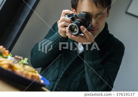 Men shooting food in a cafe 37619137