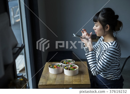 Woman photographing food in cafe 37619232