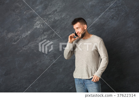 Smiling man talking on smartphone in studio 37622314