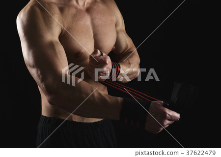 Athletic boxer wrapping hands with boxing bandage 37622479