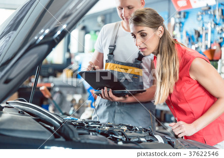 Auto mechanic showing to a customer the engine 37622546