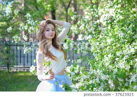 Beautiful spring girl in blooming tree 37623925