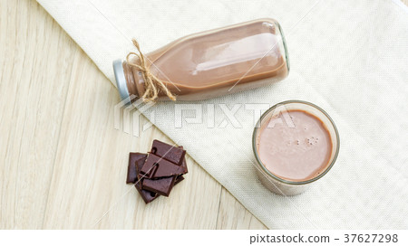Chocolate milk on a wooden table. Chocolate milk on a wooden table. 37627298