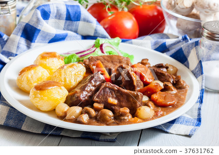 Beef Bourguignon stew served with baked potatoes Beef Bourguignon stew served with baked potatoes 37631762