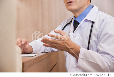 Asian Senior male Doctor talking to female patient 37634218